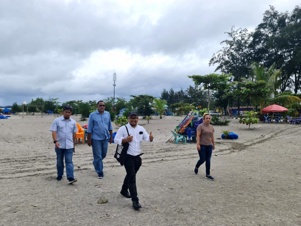 Mentors and participants walking on the beach, the possible extended location for the change project in Pariaman.