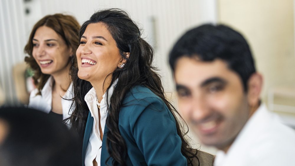 Two women and a man with happy faces.